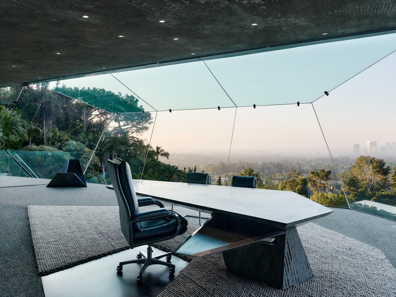 Derrière l'étonnant bureau en porte-à-faux en béton et en acier inoxydable de James Goldstein, le regard se porte sur le jardin et les vues panoramiques de Los Angeles, alors que le jour se lève sur la ville.