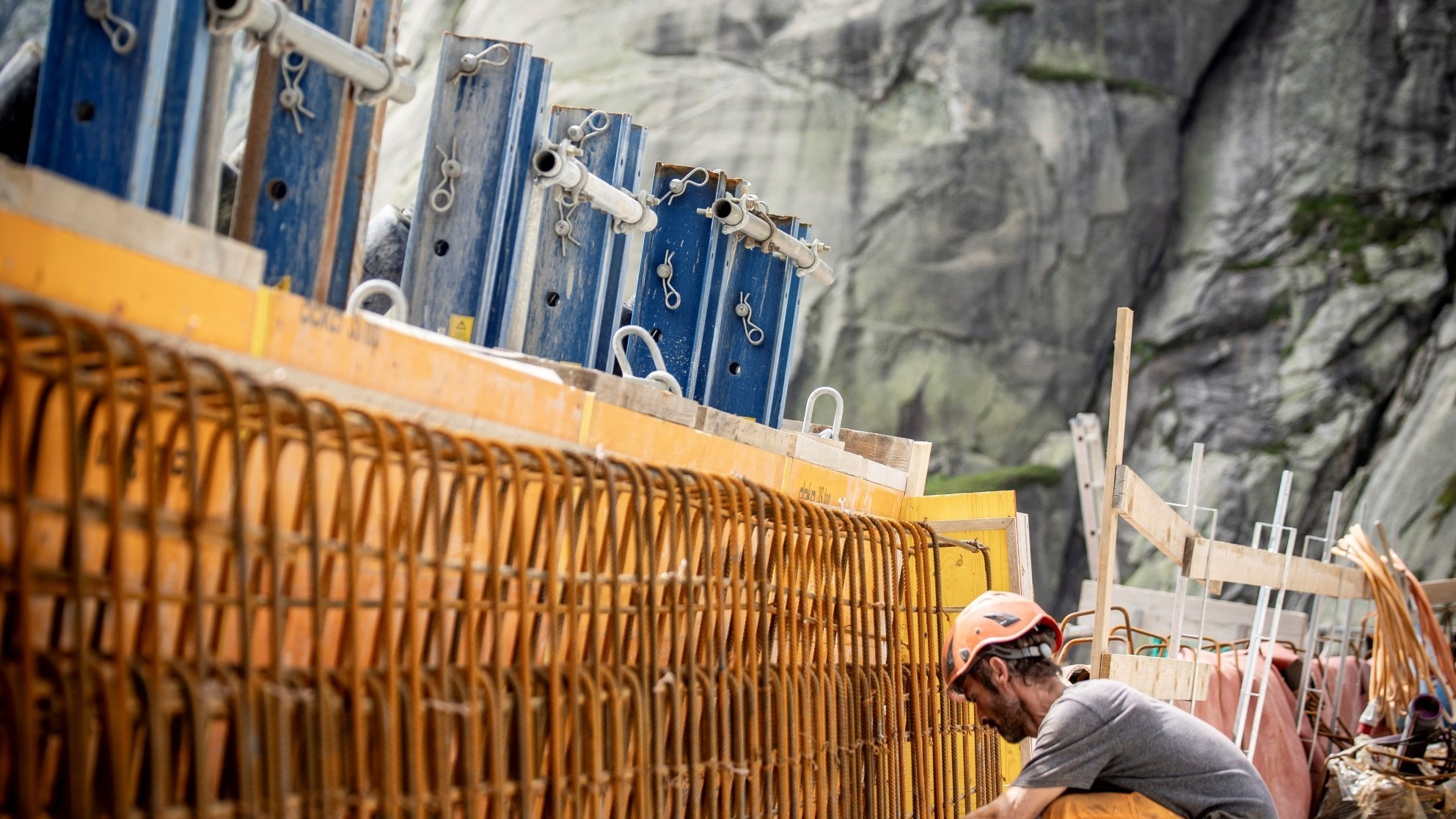 Un ouvrier lie des fers d'armature pour le parapet du barrage. Des fers d'armature ne sont posés qu'à cet endroit et dans les plaques de couronnement de 50 cm d'épaisseur. Le barrage en lui-même est conçu de manière à ne pas nécessiter d'armature.